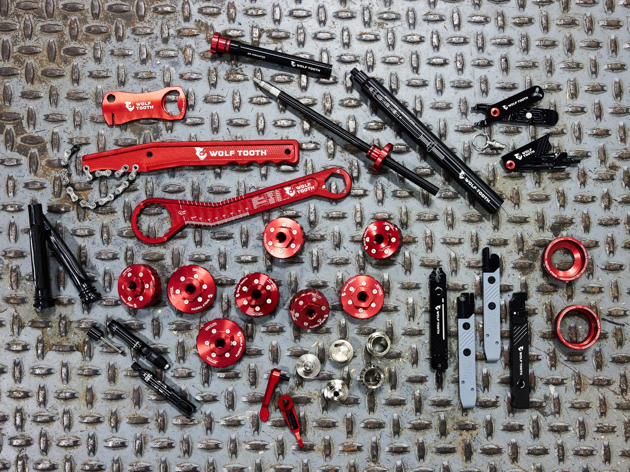 A collection of Wolf Tooth Components Pack Tools, including Pack Pliers, Pack Whip, Pack Wrench, Bottom Bracket Tools, Pack Hanger Alignment Tool, and the Encase System Bar Kit One.
