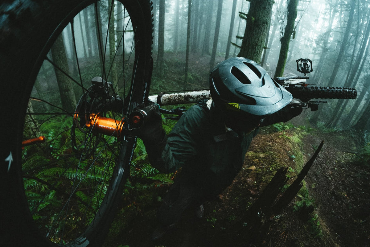 Person with a mountain bike in a forest setting