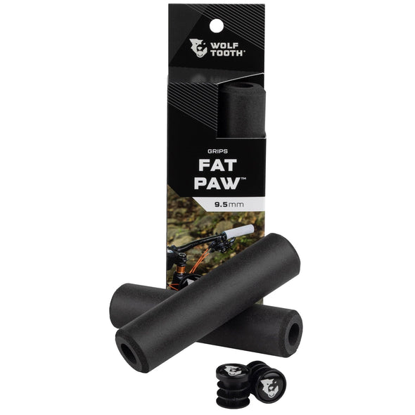 Wolf Tooth Fat Paw handlebar grips in black both in packaging and sitting in front of packaging with bar end plugs
