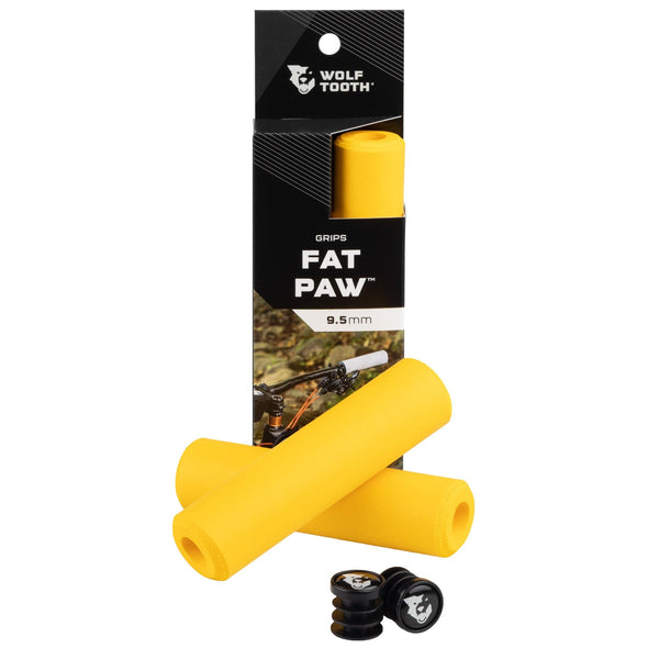Wolf Tooth Fat Paw handlebar grips in yellow both in packaging and sitting in front of packaging with bar end plugs